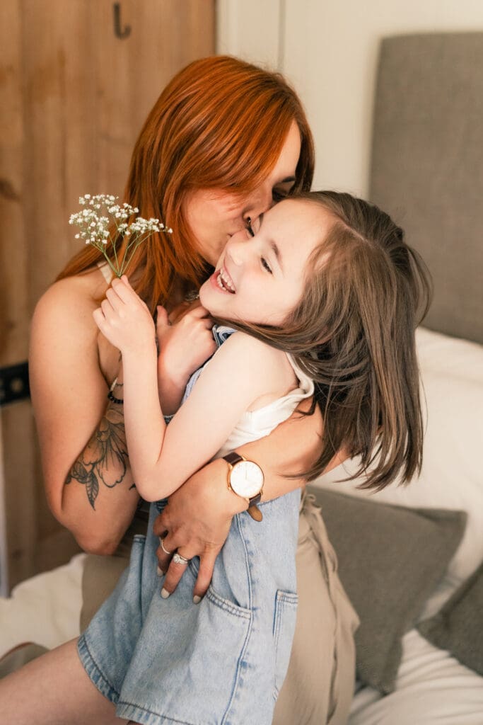 Sussex family photographer capturing candid mother-daughter hug at home