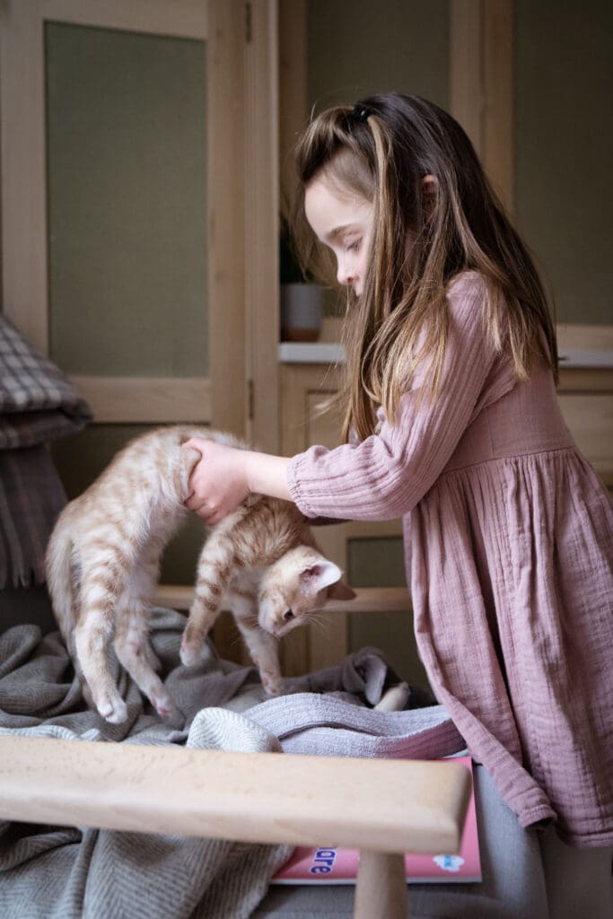 Young girl playing with pet cat during at-home photoshoot Sussex