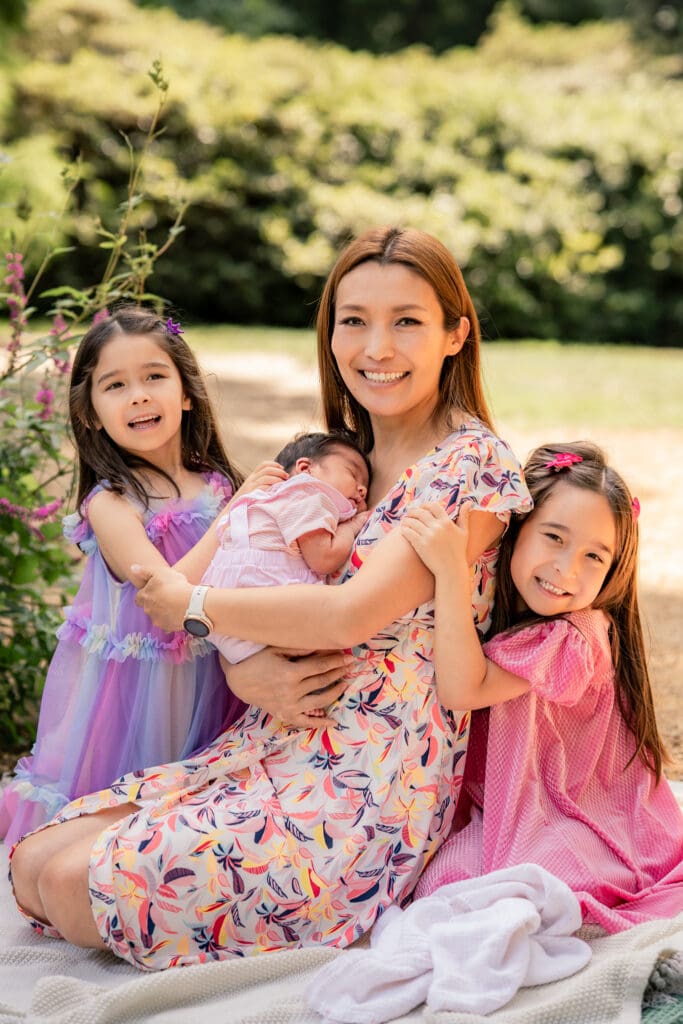 Cuddles and connection with siblings and newborn in a natural Sussex setting.