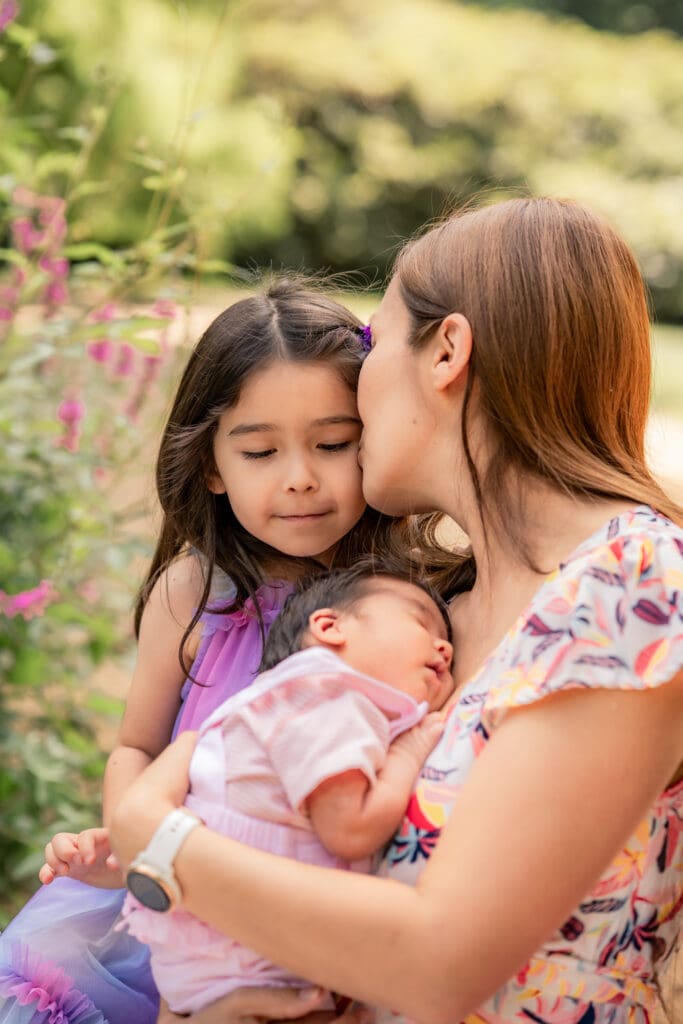 Tender outdoor moment with siblings and newborn during a Sussex family photoshoot.