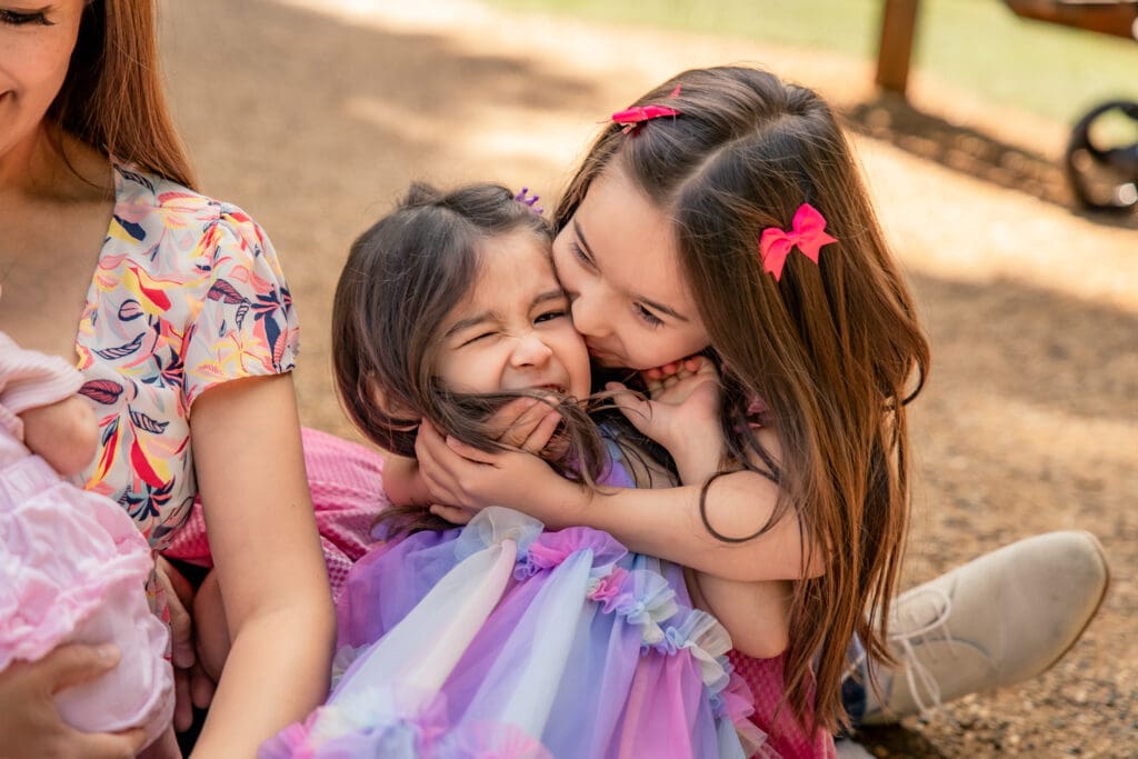 Genuine sibling affection captured during a relaxed outdoor photoshoot.
