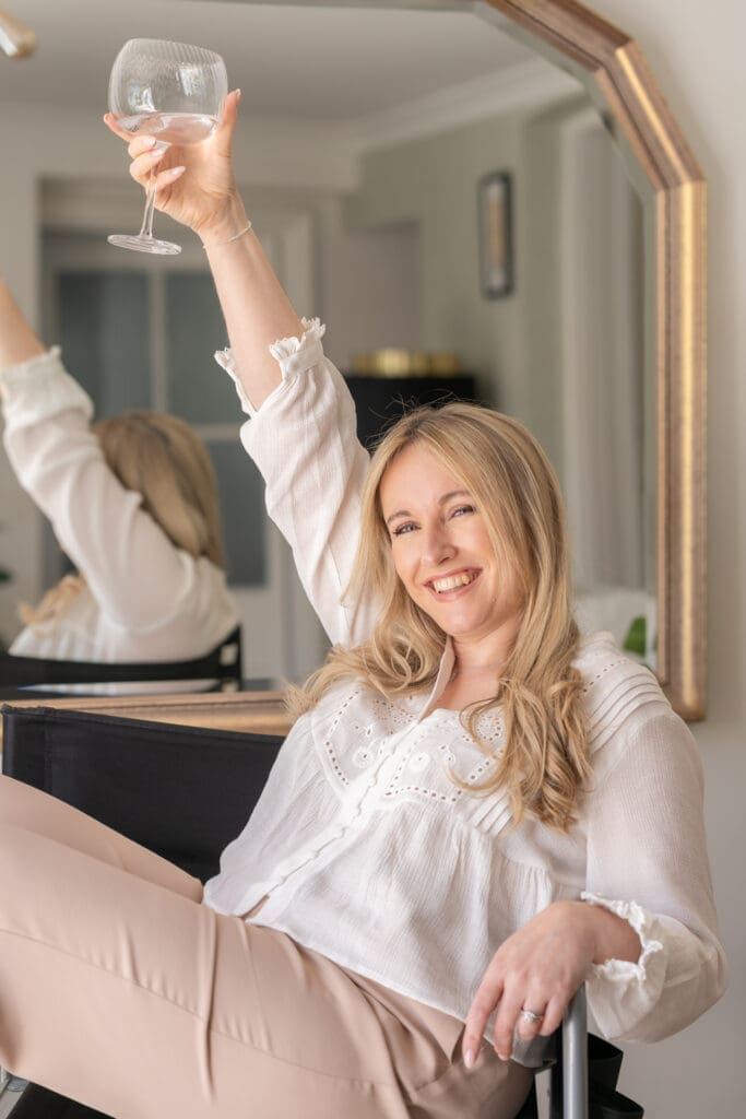 Bridal hair and makeup artist Rachel Caws celebrating with gin glass during branding photography session in Sussex