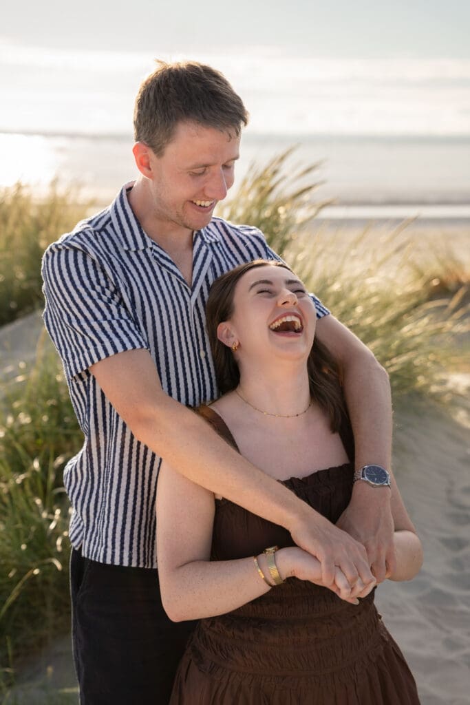 Couple sharing a playful, laughing moment during a Sussex family photoshoot.
