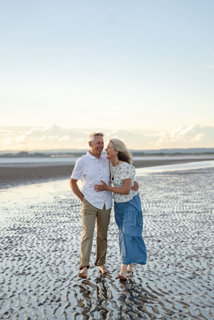 Grandparents walking together along the water's edge during a Sussex family photoshoot.