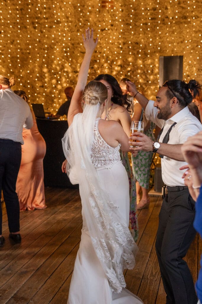 Bride dancing with her arm in the air on the dance floor