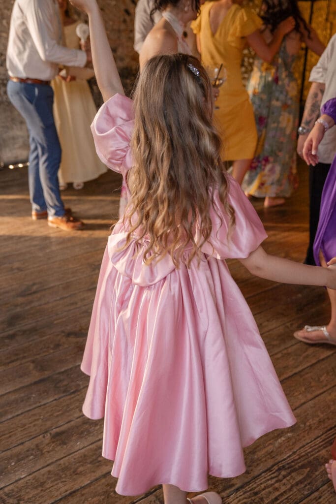 Flower girl in a pink dress dancing on the dance floor