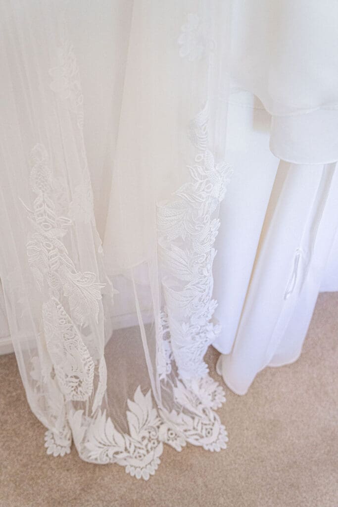 Scalloped lace edge of the wedding dress and veil on the morning of the wedding