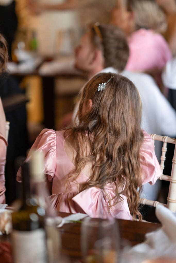Flower girl in pink sitting at the table during the speeches