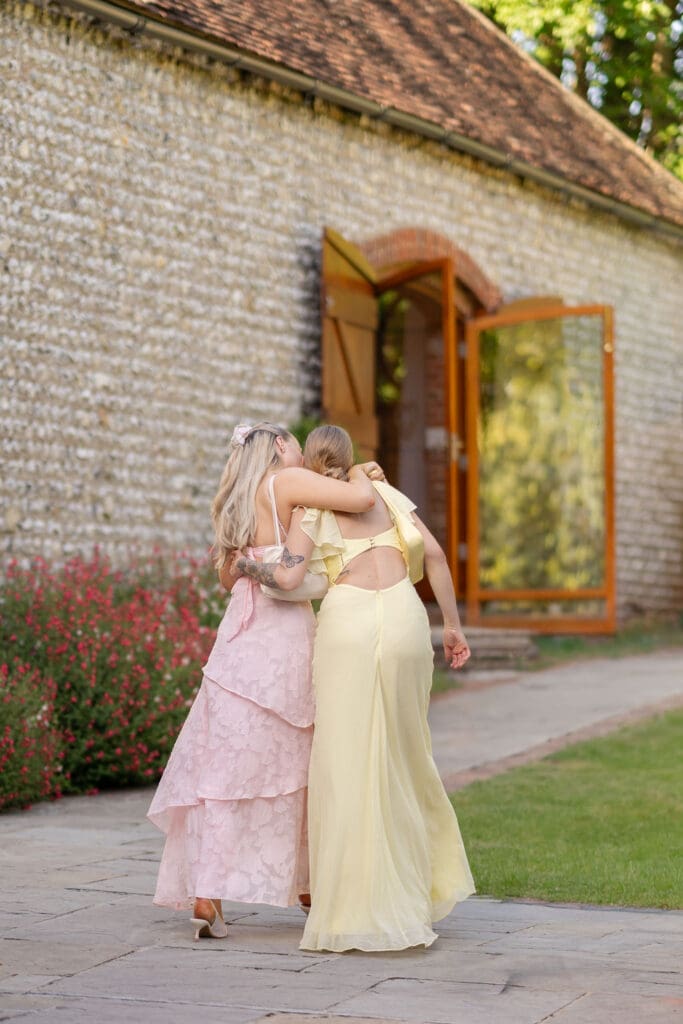 Wedding guests hugging outside the flint barn